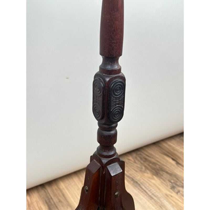 A close-up of an intricately carved furniture leg from an Antique Victorian Marble Top Plant Stand (late 19th century), featuring circular and linear designs, shown on a wood floor with a plain white background.