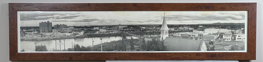 The Pearl City Antiques Framed Panoramic Photograph of Fairbanks, Alaska c. 1955 showcases a riverside town with a bridge, church steeple, clustered buildings, and distant mountains in an elegant wide wooden frame.