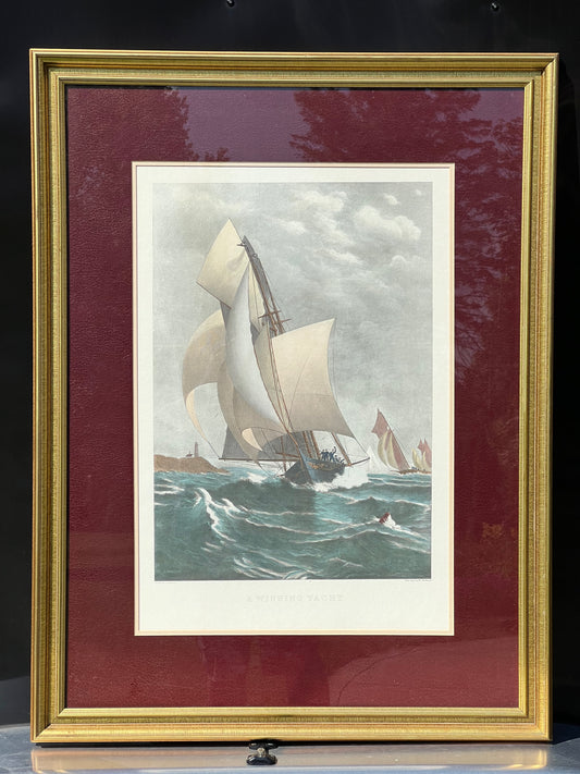 Framed Print of J.O. Davidson's "A Winning Yacht" by Pearl City Antiques, showcasing sailboats racing through choppy waters under a cloudy sky. Gold frame and maroon mat elegantly emphasize the large foreground yacht and distant vessels.