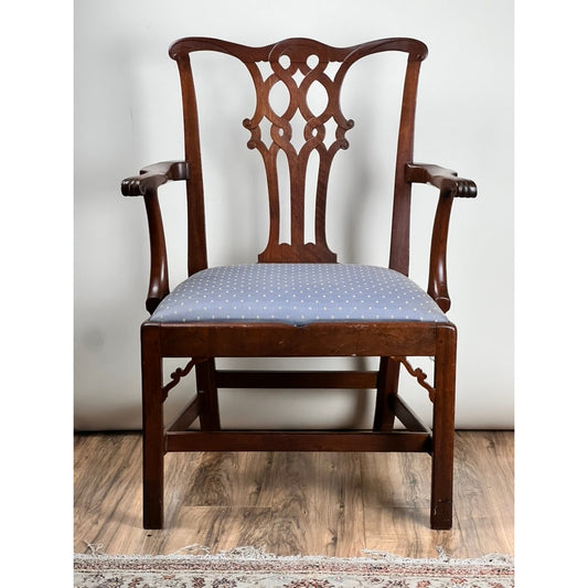 Antique Chippendale Walnut Open Arm Chair c. Late 18th Century by Pearl City Antiques featuring an ornate, carved backrest and elegantly curved arms. The seat is upholstered in light blue fabric adorned with small white dots. This exquisite piece of 18th-century furniture is displayed on a wooden floor with part of a rug visible.