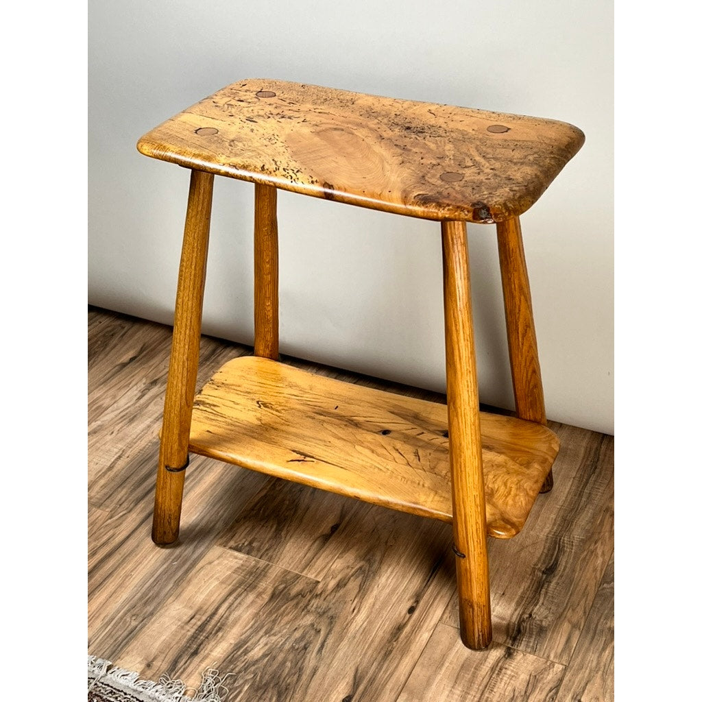 A Vintage Wabi Sabi Bench from spalted maple, signed by Neil Panyik, sits on a wooden floor against a plain light-colored wall.