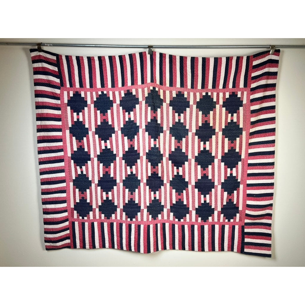 A matching pair of antique American patriotic hand-quilted Log Cabin quilts (early 20th century), featuring red, white, and blue geometric patterns, evoke classic Americana and hang as striking décor. Brand: Unknown.