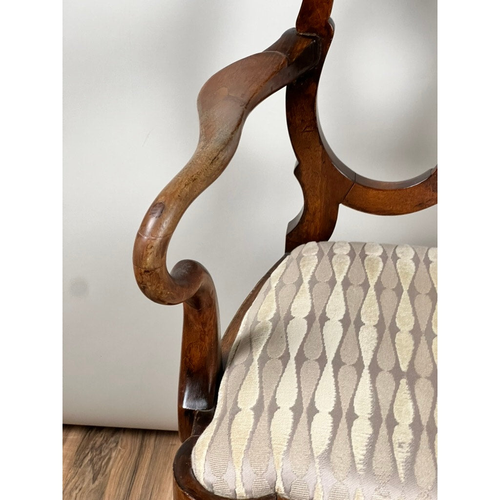 Close-up of the armrest on an Antique George III Mahogany Open Arm Chair, late 18th century, with a cushioned seat upholstered in beige fabric with a subtle geometric pattern. Plain background and wooden floor. Brand unknown.
