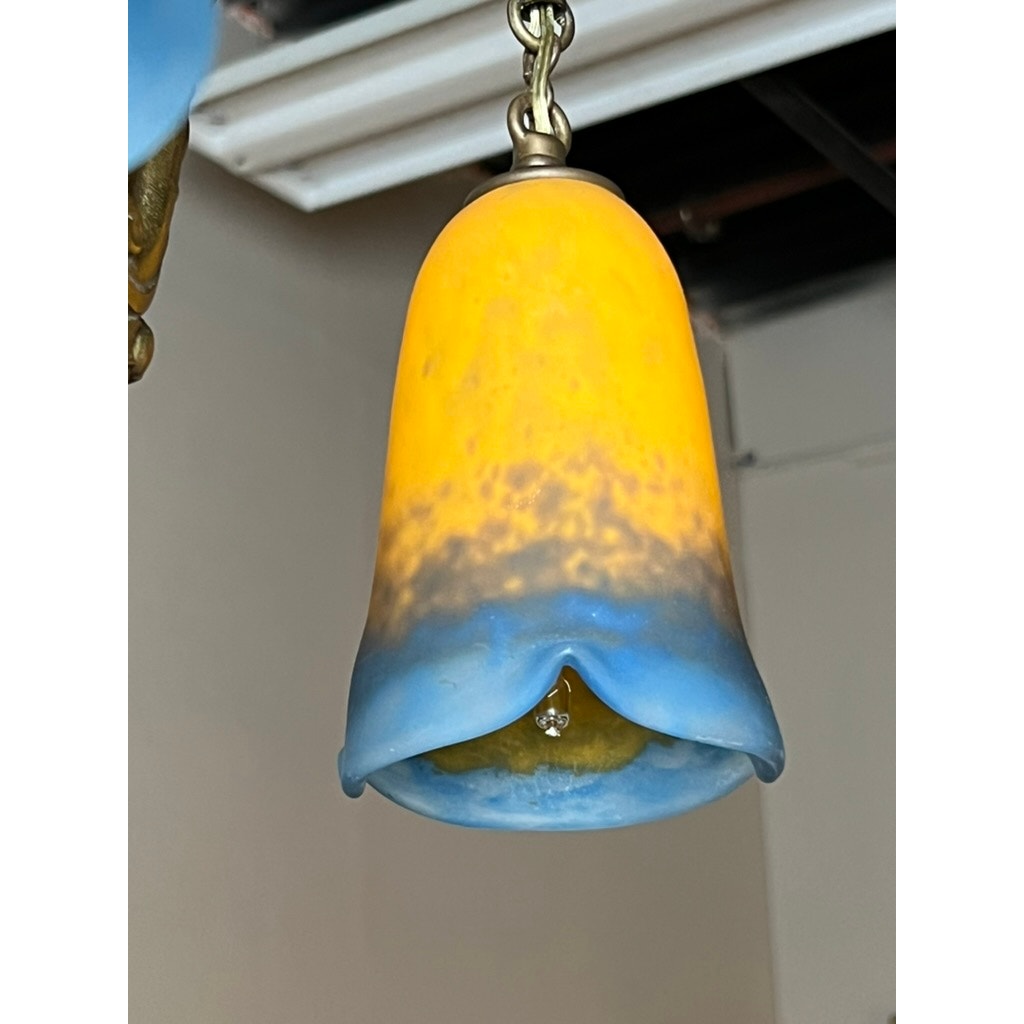 The Vintage Muller Frères Lunéville French Brass and Art Glass Four Light Chandelier features bell-shaped gradient glass shades, inspired by Art Nouveau floral designs. Partially visible bulbs evoke the iconic French vintage style of Muller Frères Lunéville.