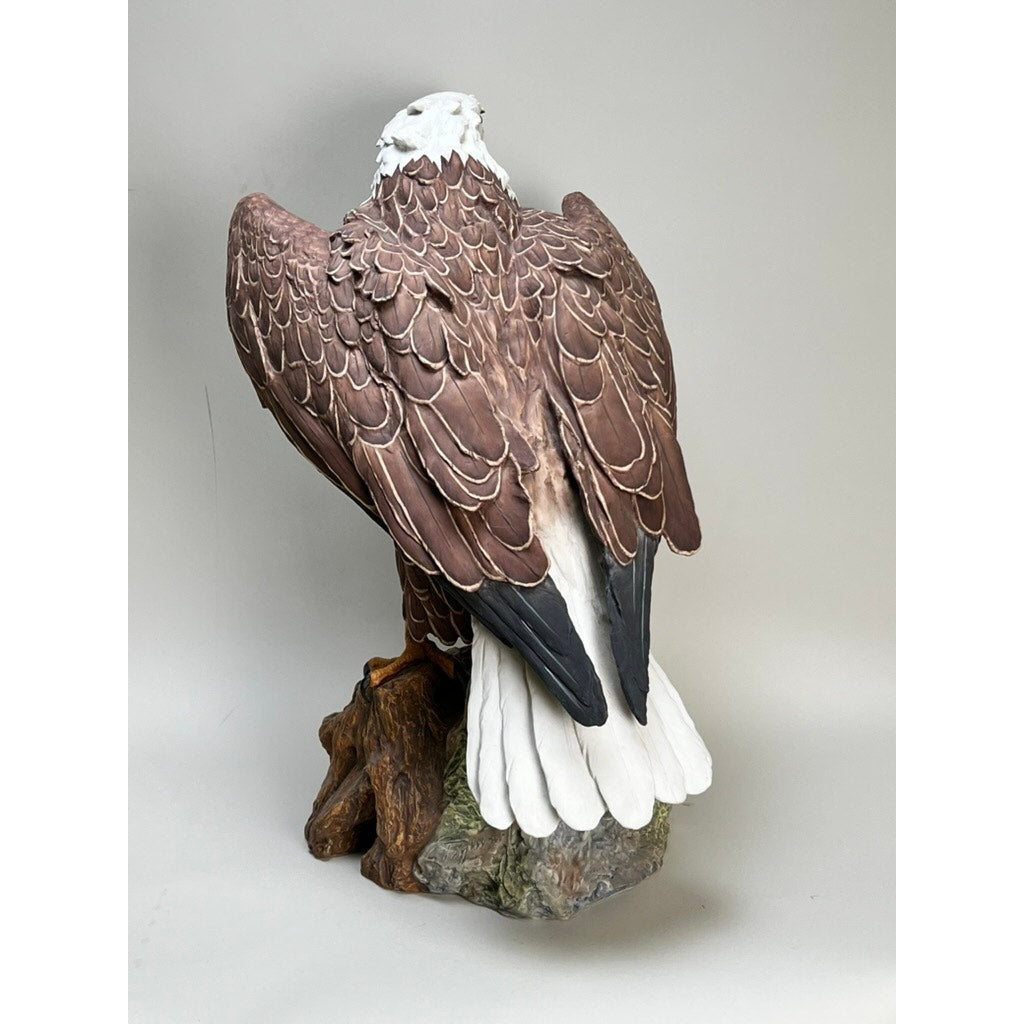 This Rare Kaiser Porcelain American Bald Eagle Sculpture (Limited Edition No. 12/200, W. Germany) features the eagle perched on a tree stump, showcasing brown feathers, a white tail, and part of its white head against a neutral background.