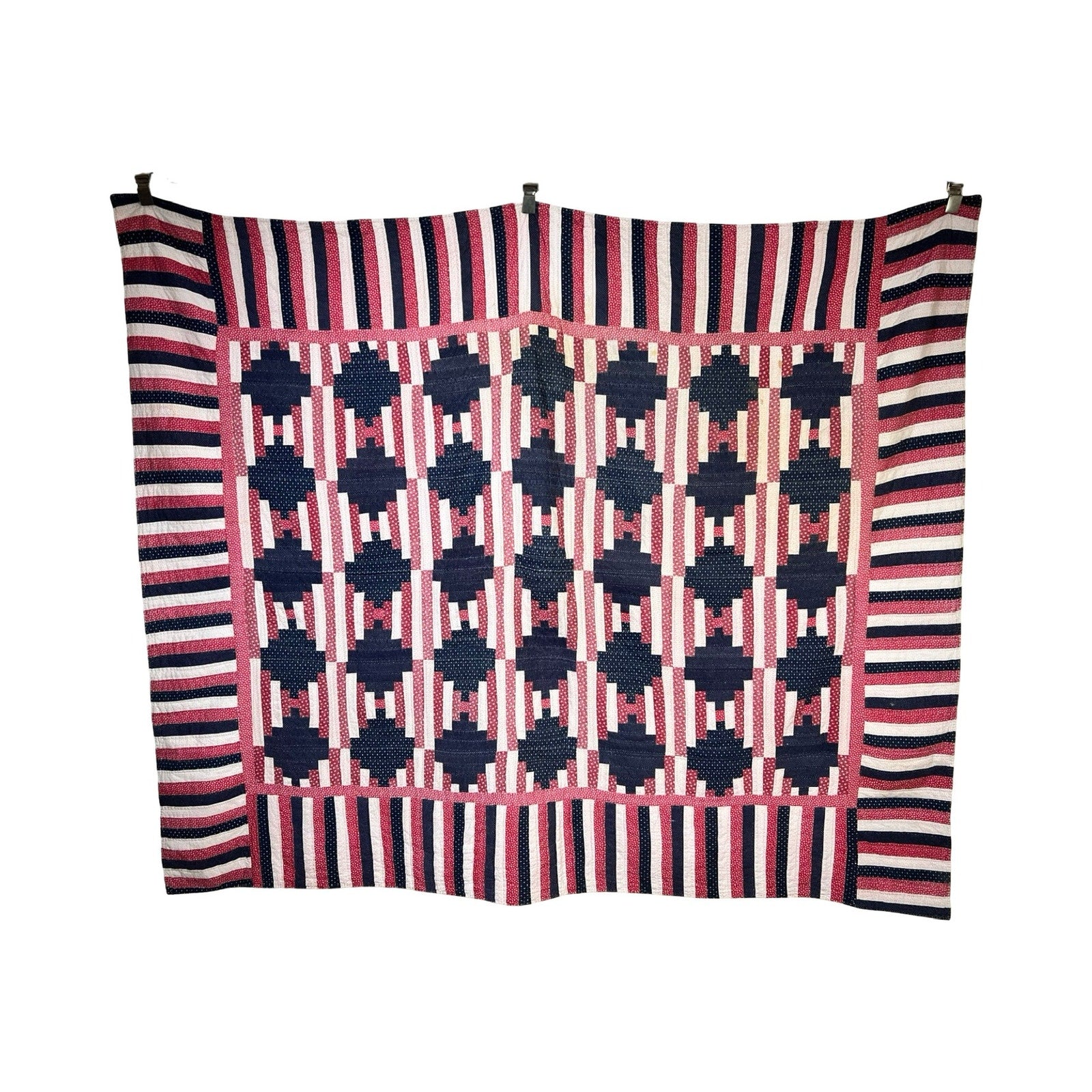 A matching pair of antique American patriotic hand-quilted Log Cabin quilts, c. early 20th century, features blue and pink geometric designs with bold navy, pink, and white striped borders—classic examples of timeless American quilting.