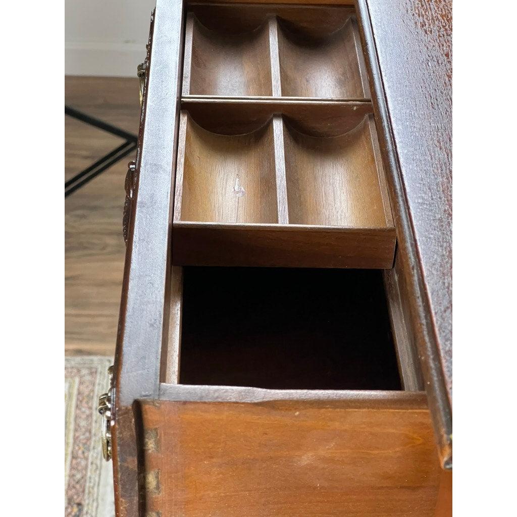 An Antique Depression Era Mahogany Two Over Three Chest of Drawers (c. 1930s) sits partially open, revealing a removable organizer tray with six compartments above an empty space. Dovetail joints and hardwood floors enhance its vintage charm by a patterned rug.