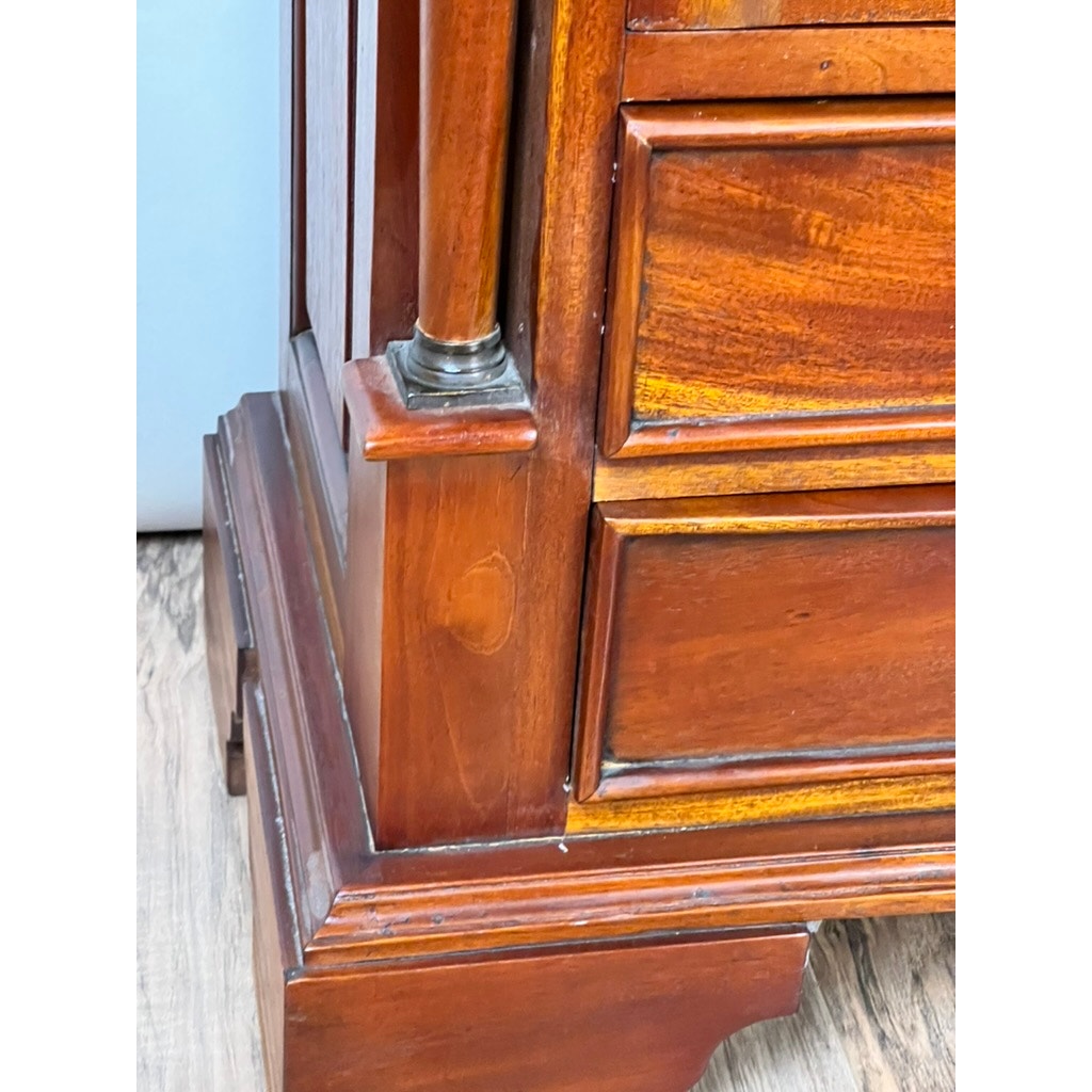 Close-up of the lower corner of a Vintage Victorian Style Glass Door Mahogany Bookcase with decorative paneling, carved accents, and a small metal detail, shown on a wood floor. Brand: None and/or Unknown.