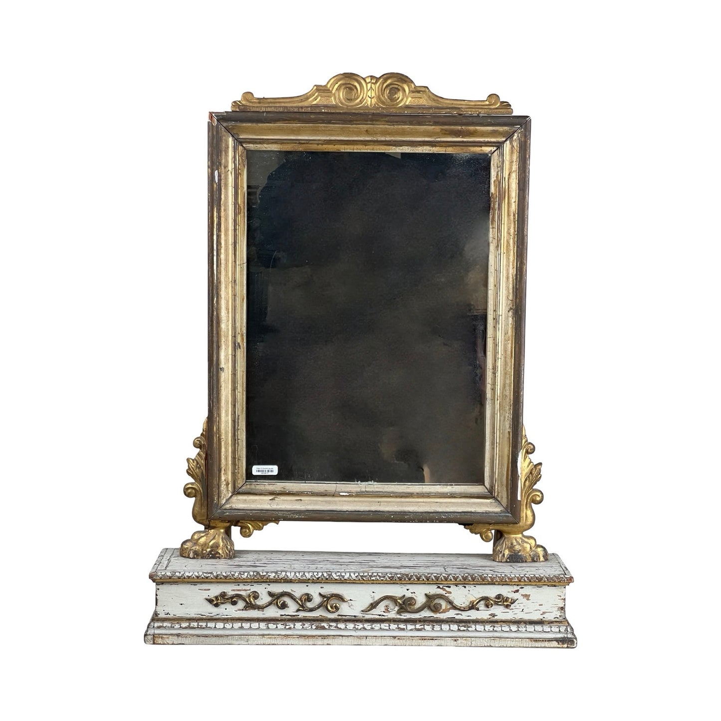 An Antique French Empire Gilt Wood Vanity/Table Mirror c. Mid 19th Century with an ornate gold frame, detailed side carvings, and a distressed white floral-accented base, shown against a plain white background. Brand unknown.