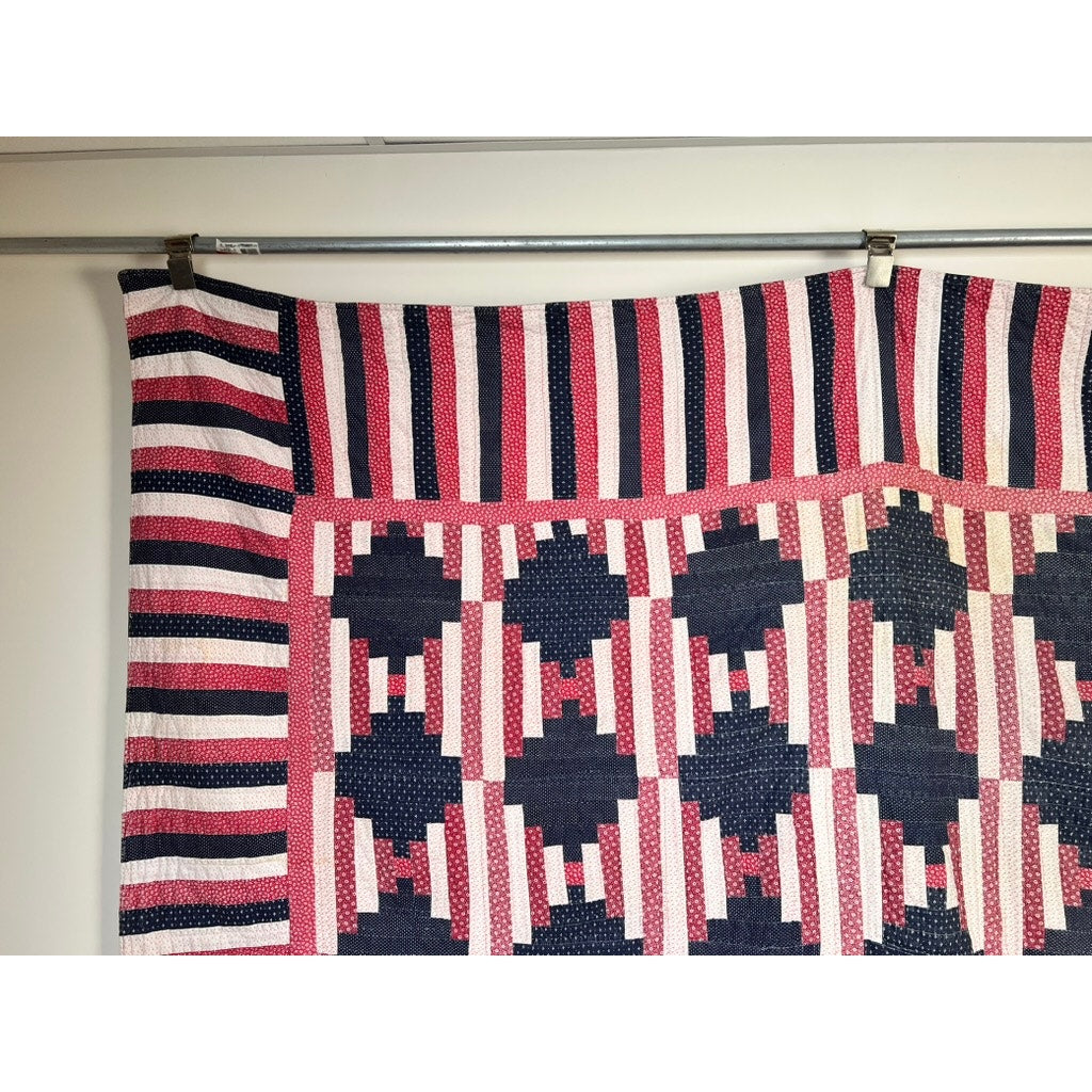 A matching pair of antique American patriotic hand-quilted Log Cabin quilts (c. early 20th century) features red, white, and blue geometric patterns, bold top border stripes, and interlocking shapes reminiscent of classic Americana.