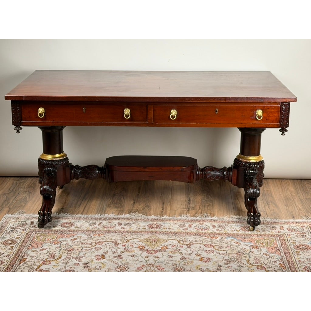 New York Classical Revival Carved Mahogany Double-Pedestal Library Table, labeled Ernest F. Hagen, featuring two drawers with brass ring pulls and ornate carved columns resting on lion-paw feet.