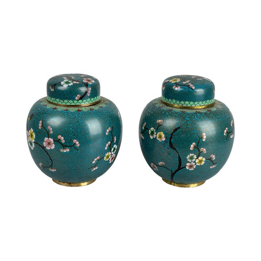 Vintage Pair of Chinese Cloisonné Ginger Jars—round, teal jars with lids, featuring floral and branch patterns in pink, white, and yellow, gold accents, an Asian-inspired design, and a decorative green band near the lid. Brand: Unknown.