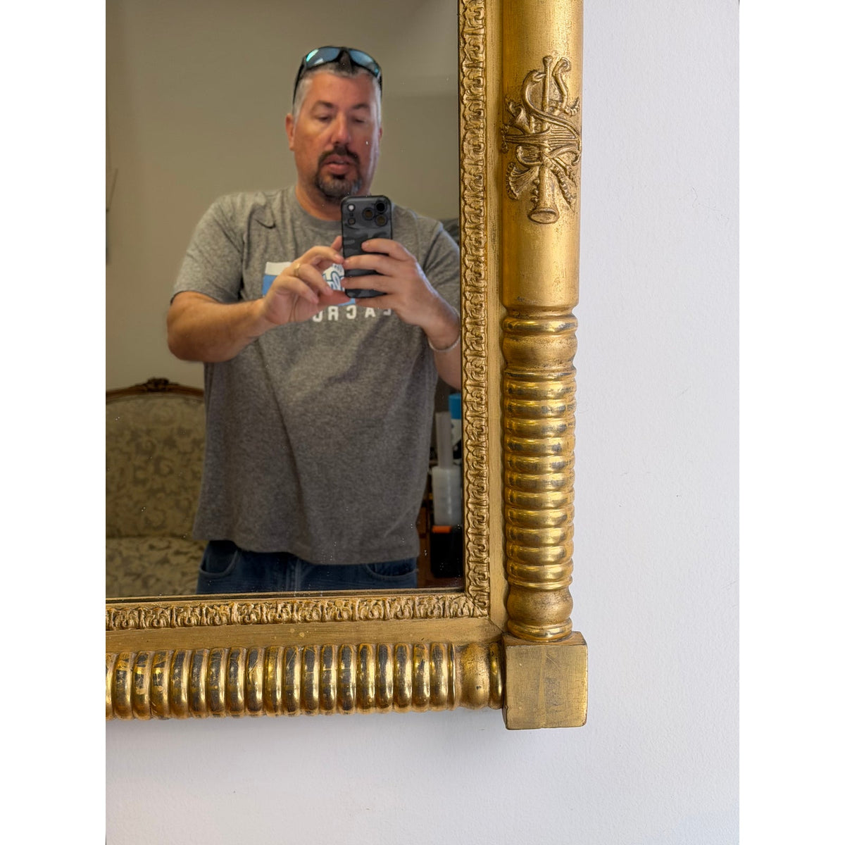 A man takes a mirror selfie in front of an American Federal Giltwood Pier Mirror, possibly Massachusetts or New York, circa 1815–1830, featuring an ornate, gilded frame with carved column details.