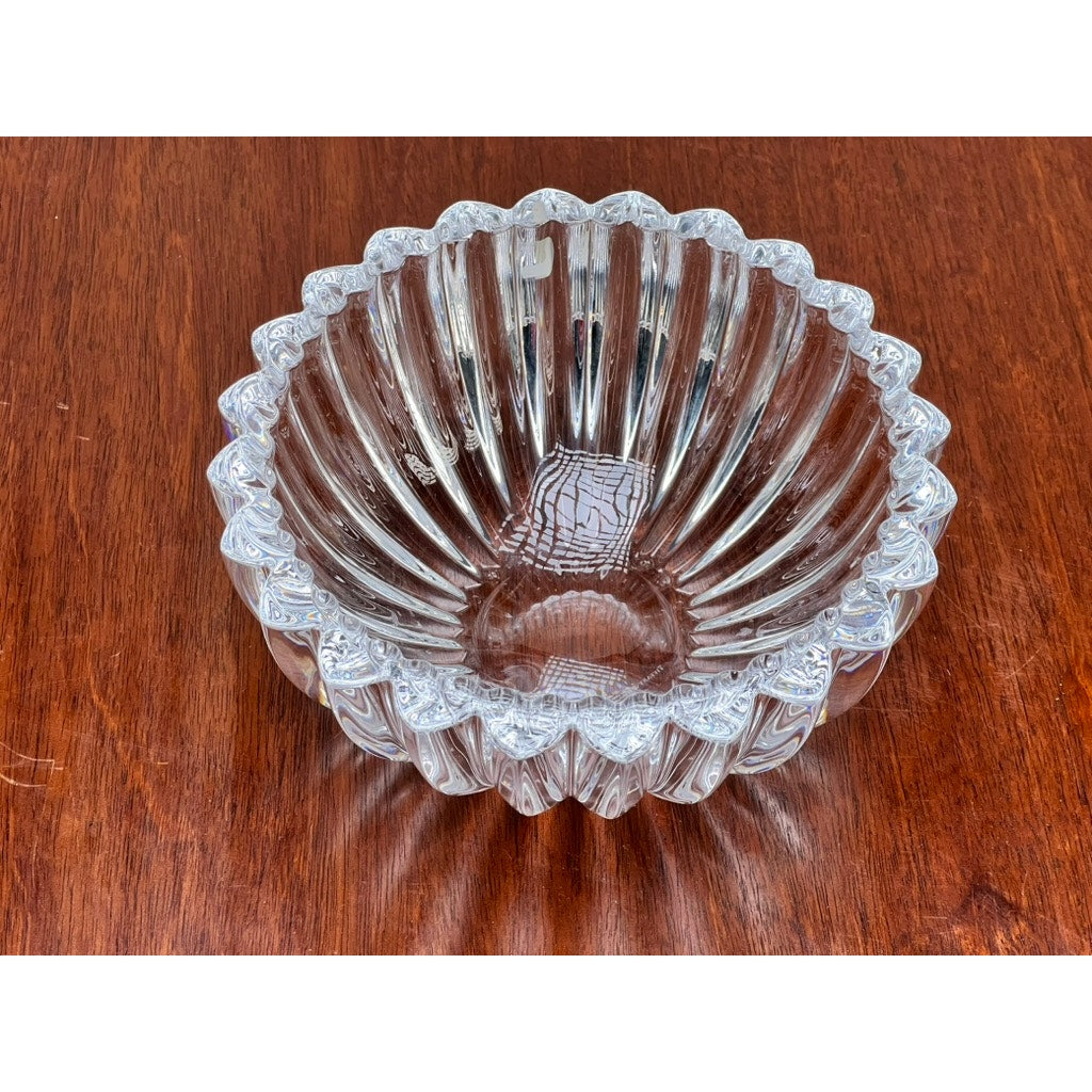 The Vintage Tiffany & Co. Crystal Bowl in a ribbed petal design by Tiffany & Co. creates a stunning centerpiece with its clear crystal and elegant detailing on the wooden surface.