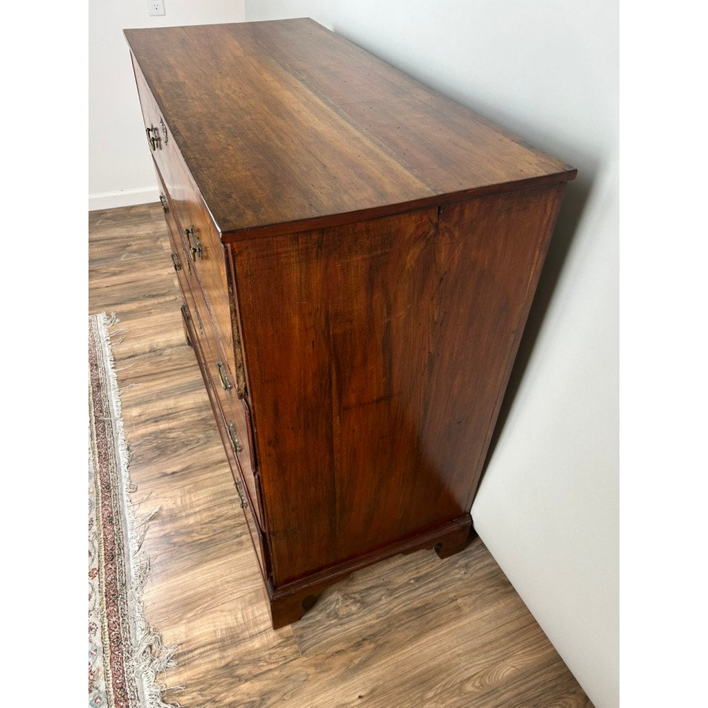 An Antique George IV Butlers Secretary from the early 19th century stands on a wood floor beside a white wall and patterned rug, its polished finish and brass handles evoking classic Regency English style.