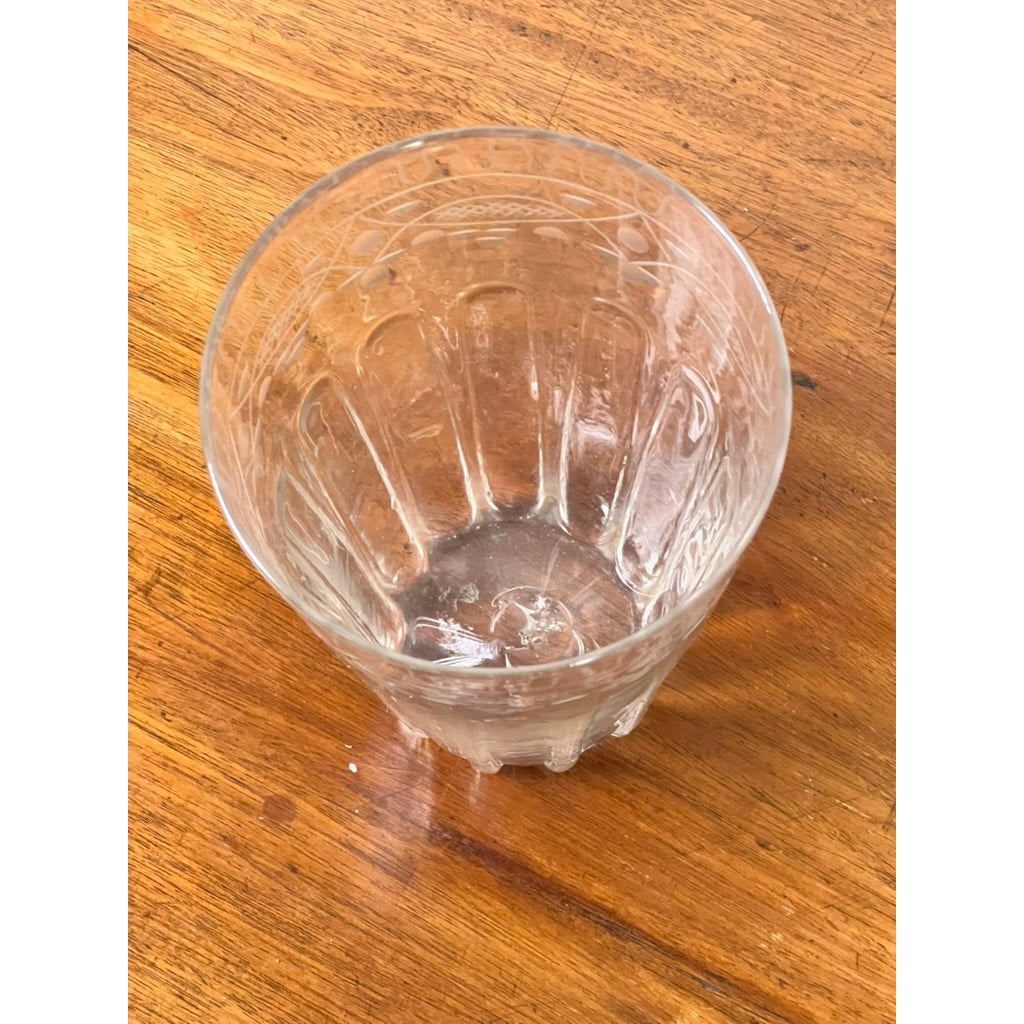 An attributed Boston & Sandwich wheel engraved, mold-blown glass table vase (circa 1845–1860) rests on a wooden surface. Reminiscent of Victorian art glass, the clear vase features vertical grooves and decorative, wheel-engraved patterns near its rim.