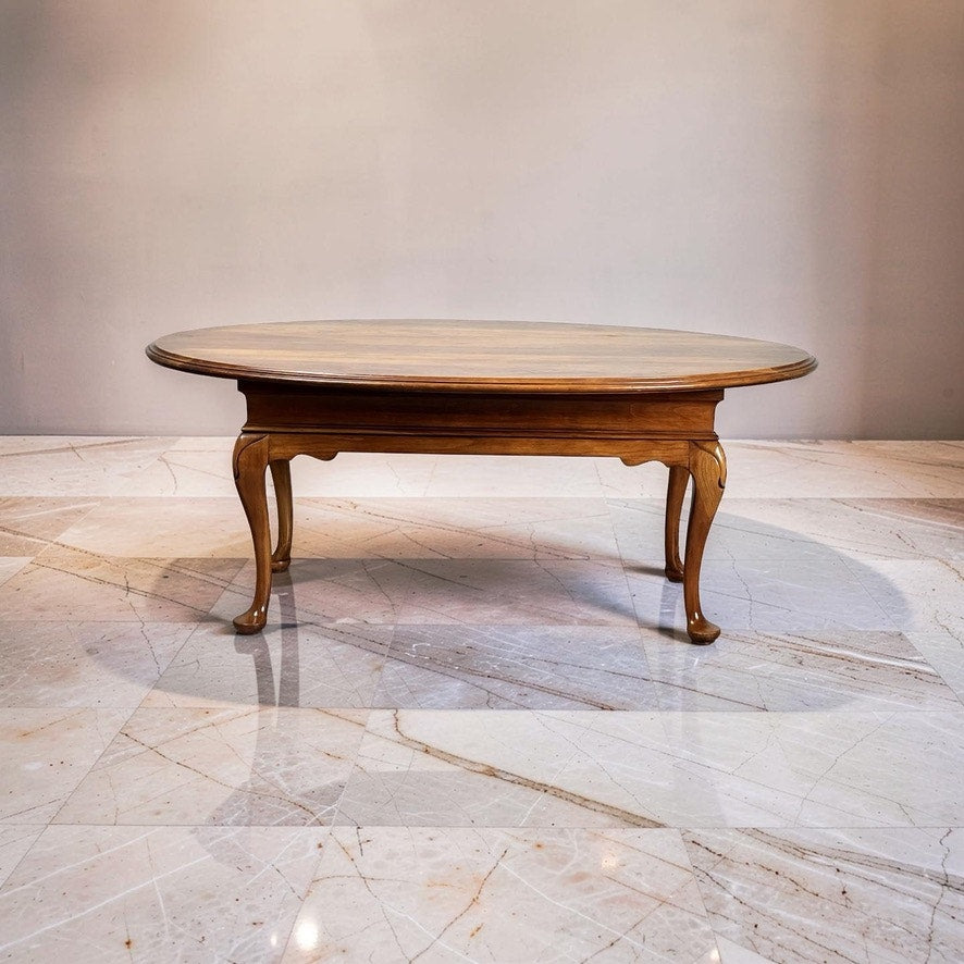 A Vintage Solid Cherry Queen Anne Style Coffee Table, attributed to Pennsylvania House, with elegant curved legs, stands on a polished marble floor against a plain light wall.