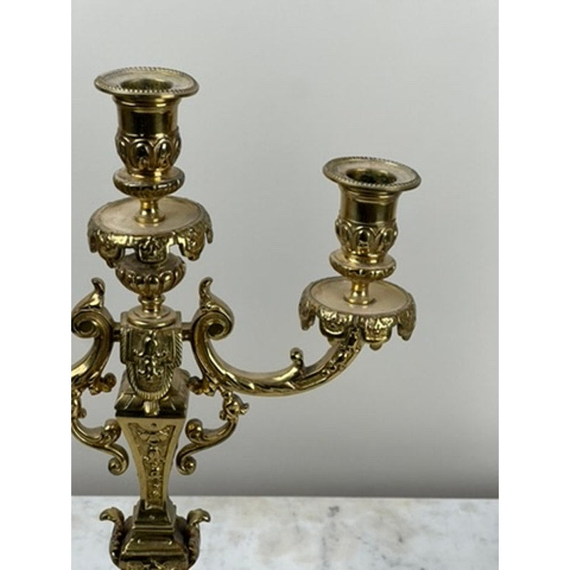 A close-up of an antique pair of late 19th-century brass three-light candelabra with intricate details, set on a white marble surface against a plain light background—ideal for elegant Victorian home decor.