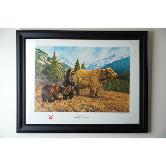 Limited Edition Print “Curious Trio” for Ruger North American by Frank Cable (Signed and Numbered 186/950) from Pearl City Antiques features a grizzly bear with two cubs standing in a grassy clearing, surrounded by pine trees and snow-capped mountains. This framed wildlife art print beautifully captures the natural majesty of the scene.