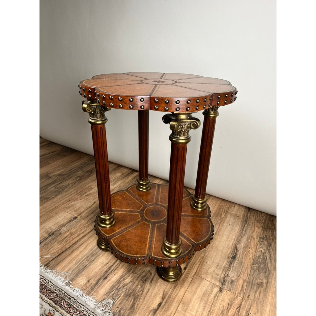The Vintage Maitland-Smith Leather-Clad Occasional Table by Maitland Smith features two tiers, gold accents, carved edges, four fluted columns, and a warm brown finish—reminiscent of classic vintage style and perfect beside a patterned rug.