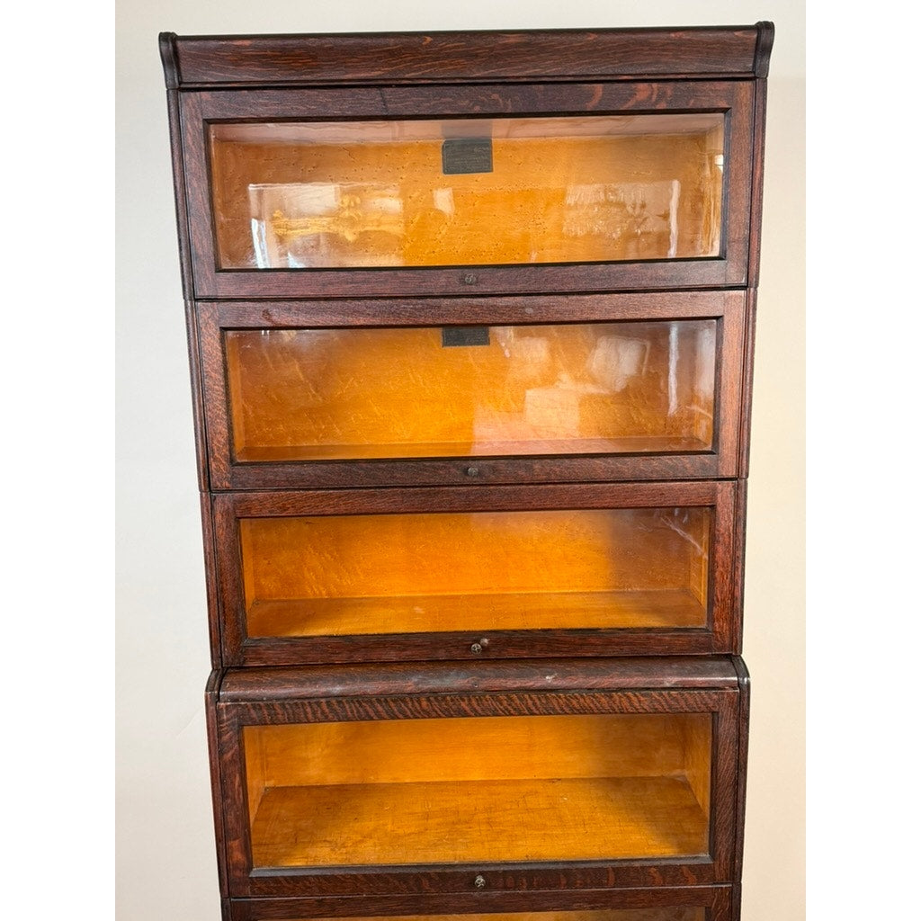 An Antique Hale System Quarter-Sawn Oak Five-Stack Barrister Bookcase by Camden Cabinet Company, c. 1910, featuring five glass-fronted shelves, stands empty and closed against a plain background.