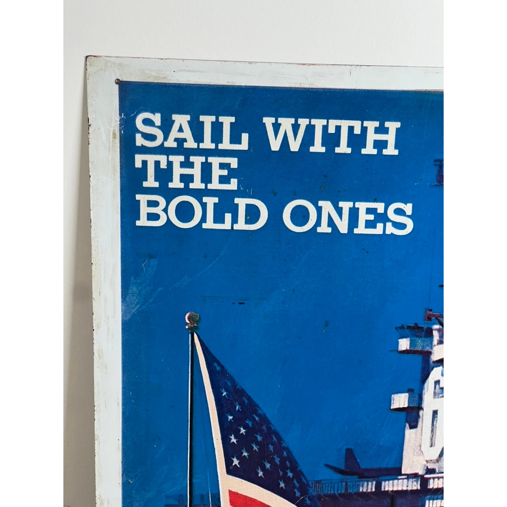 A close-up of an original Vietnam Era double-sided U.S. Navy recruiting tin sign by artist Lou Nolan, featuring the USS Saratoga and the slogan "SAIL WITH THE BOLD ONES" in white on blue—a striking collectible military sign.