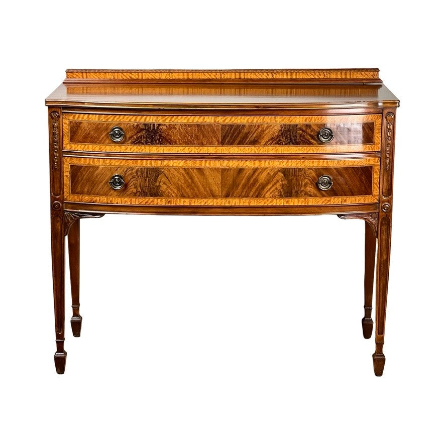 A Vintage Federal Style Bow Front Mahogany Sideboard by Paine Furniture Boston, this dresser features two drawers, decorative metal handles, carved details, and a polished brown finish with lighter inlay accents reflecting true Federal style.