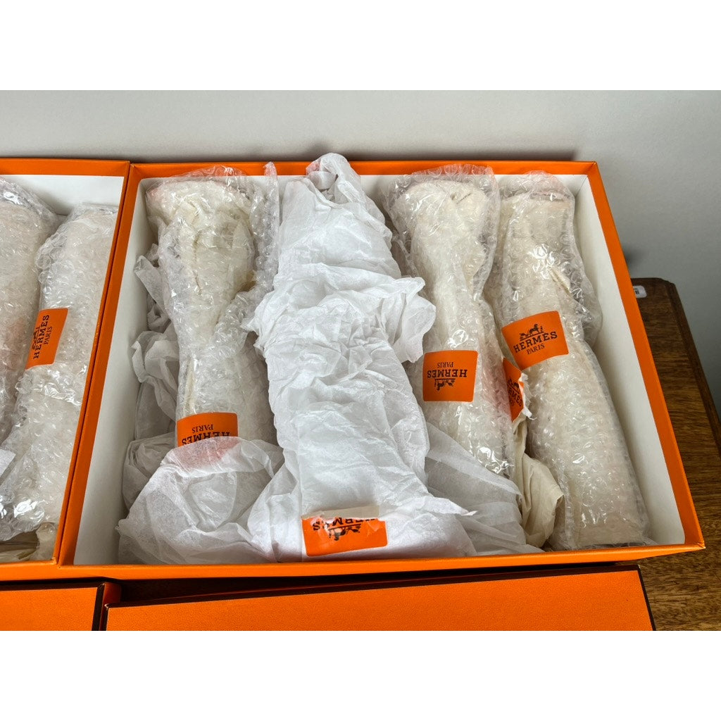 A set of eight Hermès Crystal Champagne Flutes by Saint Louis France (10.5”), carefully wrapped and sealed with Hermès Paris stickers, presented in an iconic orange Hermès box.