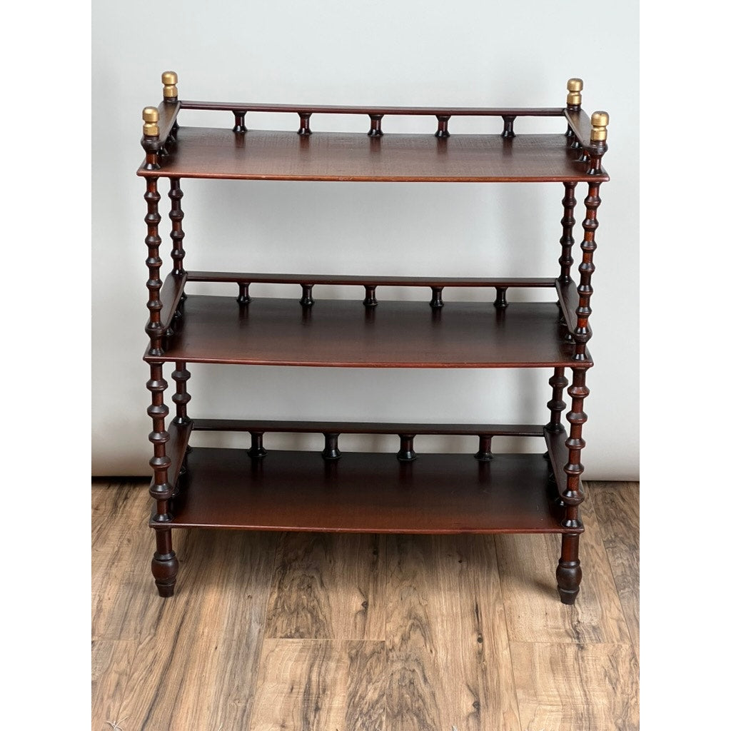 A Vintage Bobbin-turned, Three Shelf Wooden étagère or Whatnot stands on a wooden floor against a light wall, featuring bobbin-turned shelves and gold finials on the top corners. Brand: None/Unknown.