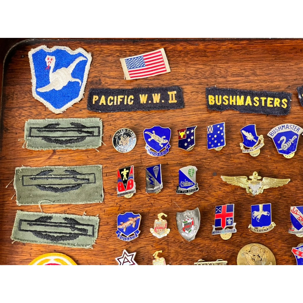 A set of WWII 158th Infantry Bushmasters patches and pins from Frank W. Slatcher, Company I, Pacific Theater—includes insignias, rank stripes, and an American flag patch—ideal memorabilia for WWII collectors.