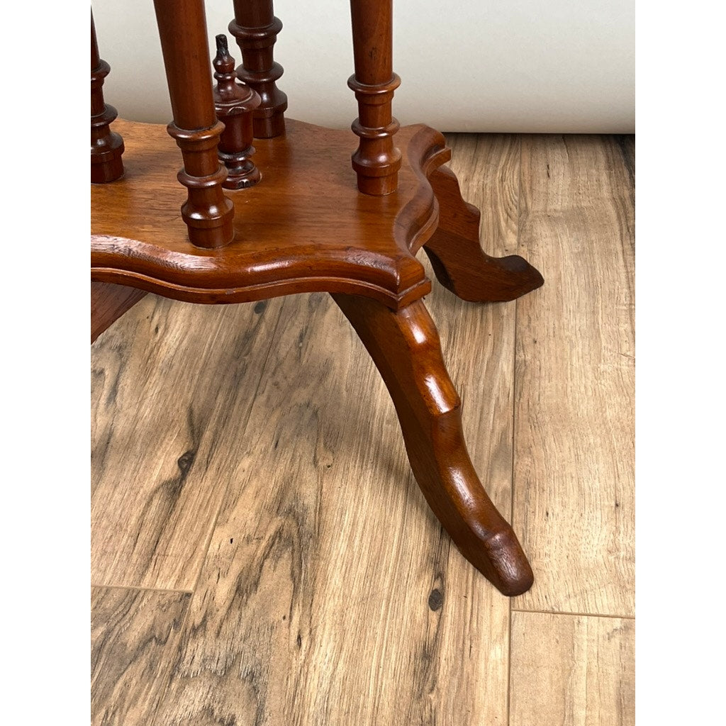 Close-up of a polished leg with ornate curves, standing on a light brown floor—highlighting the craftsmanship of this Antique Victorian Walnut Turtle Top Candle Stand, late 19th century.