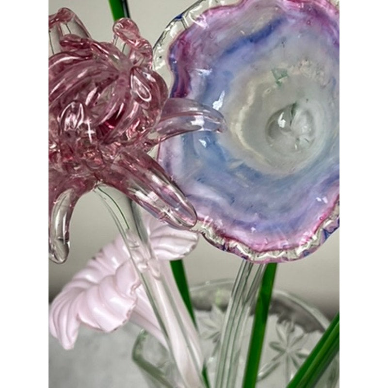 Close-up of Vintage Bouquet Murano Art Glass Long Stem Flowers and Butterflies: a pink flower with clear petals, a blue-purple bloom with a textured center, and green glass stems create this stunning hand-blown arrangement. Brand: Unknown.