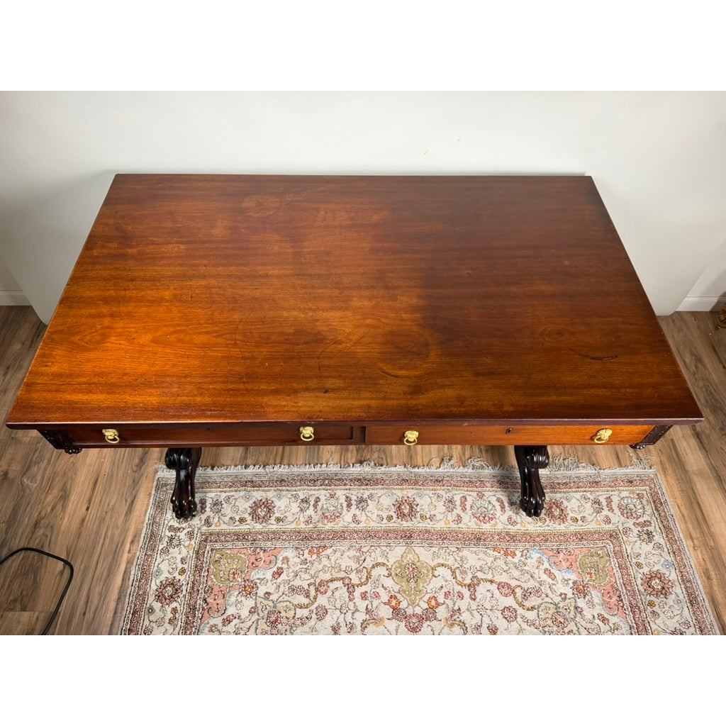 High-angle view of a New York Classical Revival Carved Mahogany Double-Pedestal Library Table, labeled Ernest F. Hagen, circa 1890–1925, with two pedestal bases, carved claw-and-ball feet, and brass drawer pulls.
