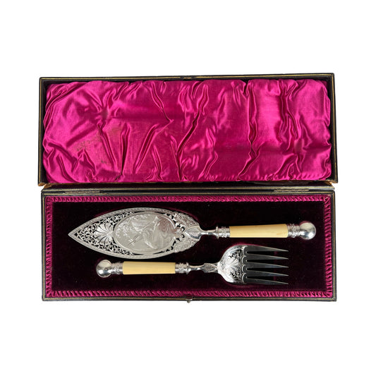 Antique Victorian silver-plated fish serving set, complete with a serving knife and fork featuring ivory-colored handles, presented in an original fitted box lined with deep pink satin and dark velvet.