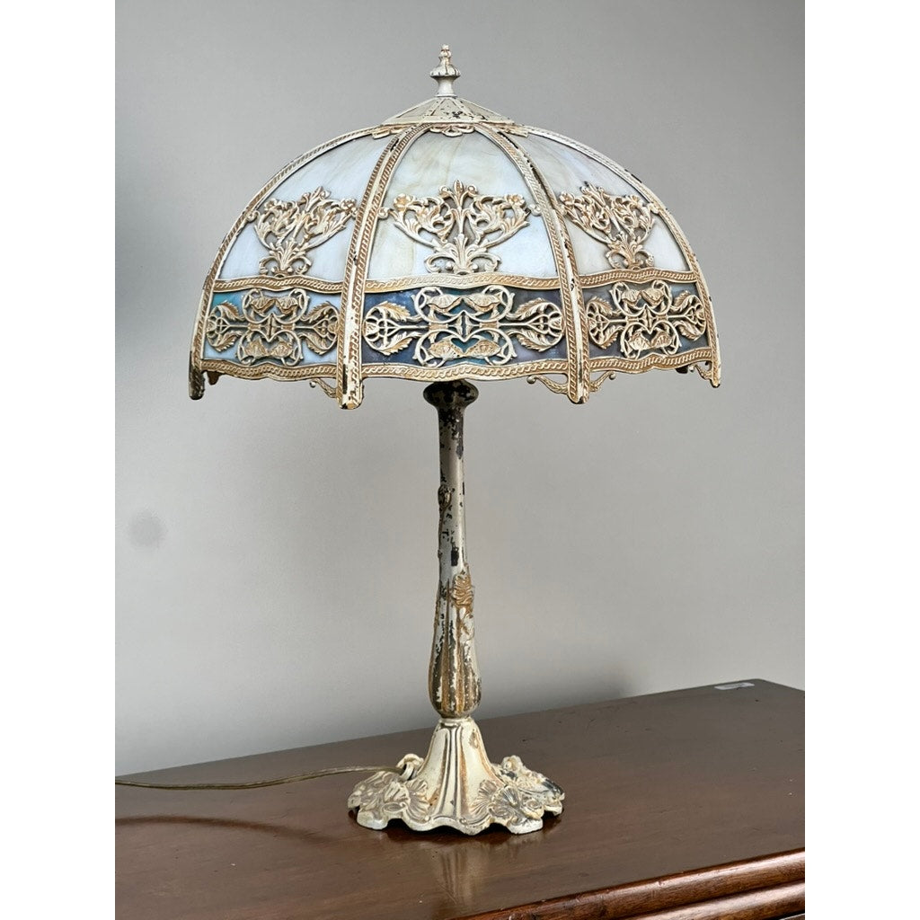 A Vintage Art Nouveau Slag Glass Two-Light Table Lamp (c. 1935–1955) with a dome-shaped stained glass shade and ornate metal base sits on a wooden surface, ideal for decorative lighting. Brand: Unknown.