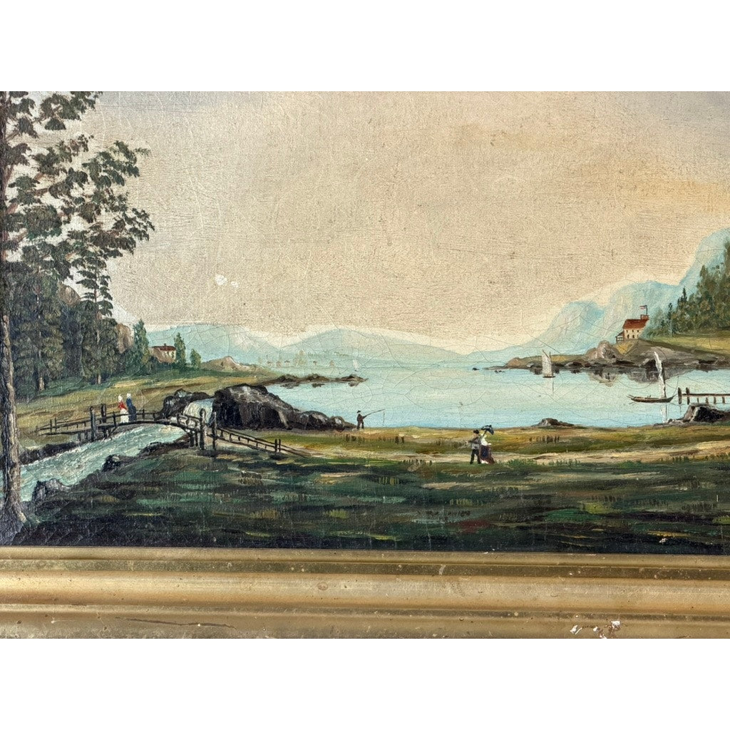 The 19th Century American Folk Art Adirondack or New England Resort Hotel Oil Painting from Pearl City Antiques features a serene landscape with a lake, trees, hills, and small houses that capture the nostalgic charm of 19th-century American folk art. Figures stroll along a winding path as a stream gently flows into the tranquil lake, all beautifully presented in an elegant gold frame.