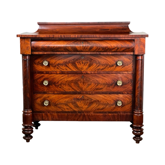 The Antique American Empire Albany Four Drawer Chest c. 1840 features richly finished flame mahogany, four drawers with brass round handles, decorative grain patterns, and two elegant turned front legs. Brand: None/Unknown.