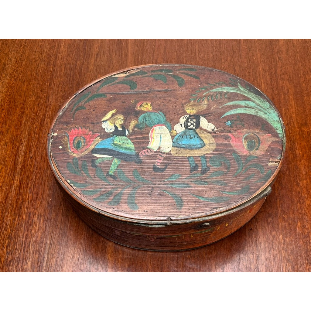 This Antique German Polychrome Painted Bentwood "Spanschachtel" Ribbon Box (late 18th century) features an oval shape, a painted lid with three figures dancing in folk dress, and detailed European floral and leaf motifs.