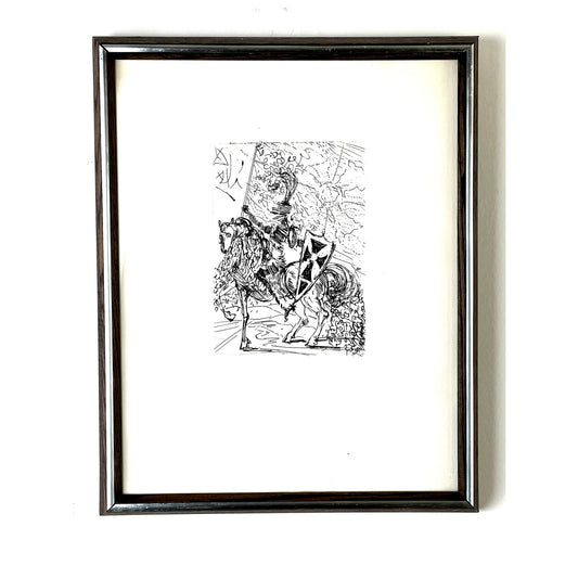 Pearl City Antiques presents the Salvadore Dali “El Cid” etching, featuring a striking black and white depiction of El Cid in armor on horseback, holding a shield adorned with a triangular pattern. The medieval background is infused with surrealist elements characteristic of Dali’s style. This framed piece comes with a Collectors Guild certificate of authenticity en verso.