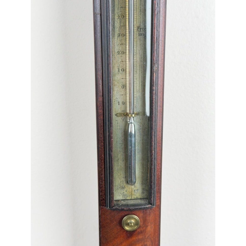 Close-up of an English Regency Mahogany Stick Barometer by Thomas Jones, Liverpool, c. 1820, a wooden stick barometer showing a glass tube with a mercury reservoir and a numbered scale.