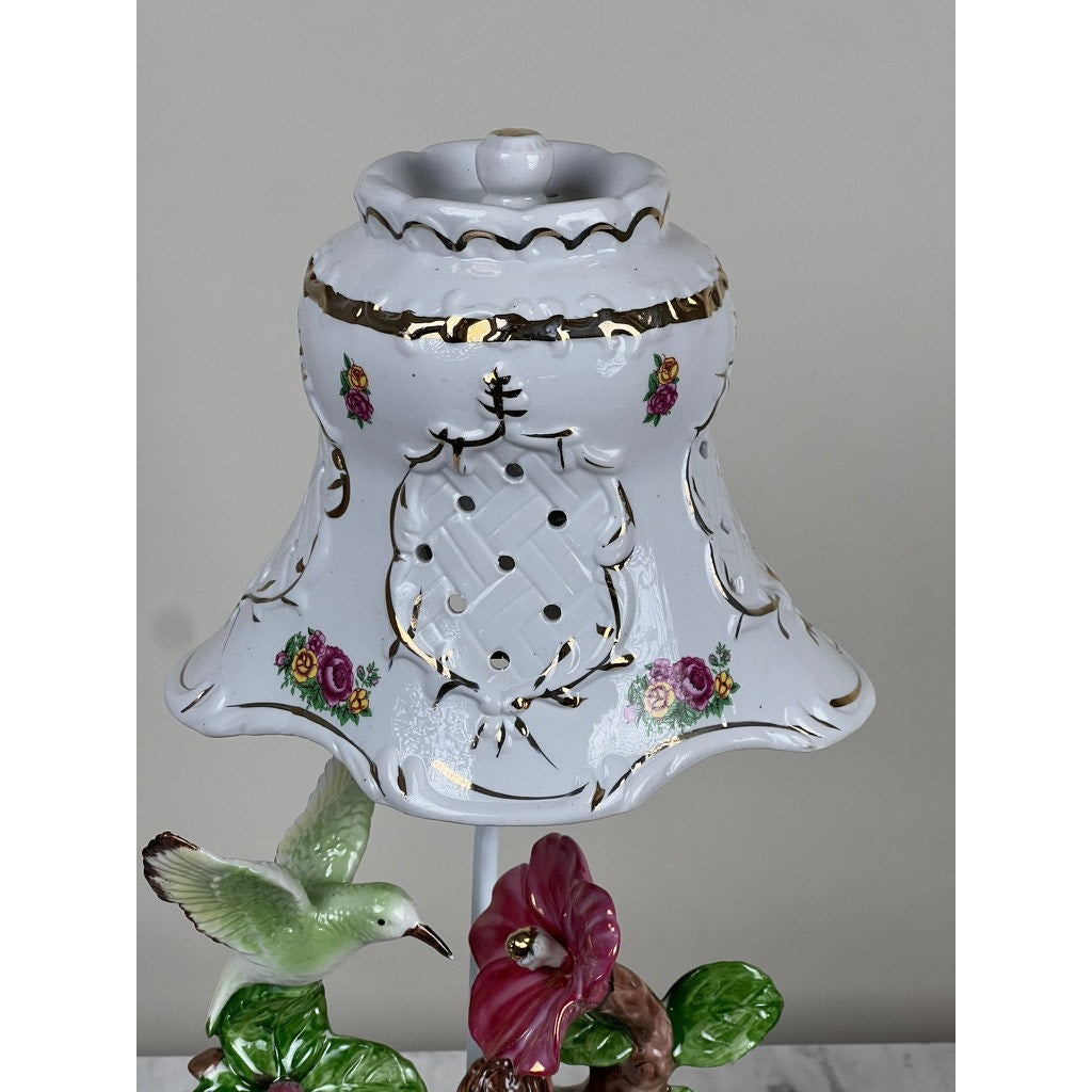 Vintage Lena Liu Porcelain Hummingbird Accent Lamp featuring a white flared shade with gold trim, pink floral patterns, cutout details, and a base adorned with a green hummingbird and pink flower. Brand: Unknown.