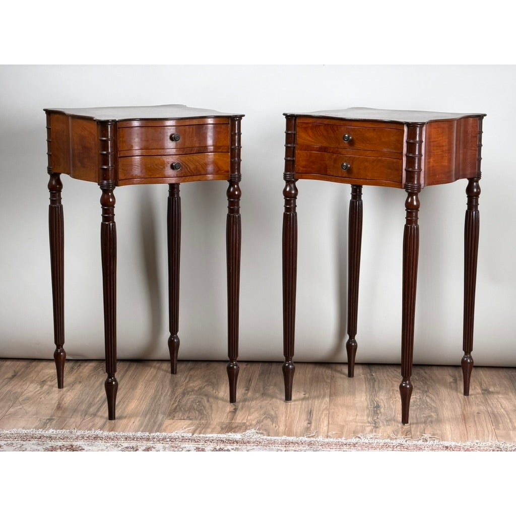 A pair of American Classical Revival Mahogany Two-Drawer Work Tables with two drawers, fluted legs, and dark round knobs.