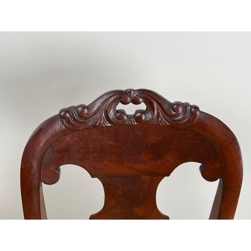 Antique American Empire Flame Mahogany Saber Leg Side Chair, mid-19th century, featuring an ornate carved backrest with scrollwork and a dark flame mahogany finish, shown against a plain light background. Brand unknown.