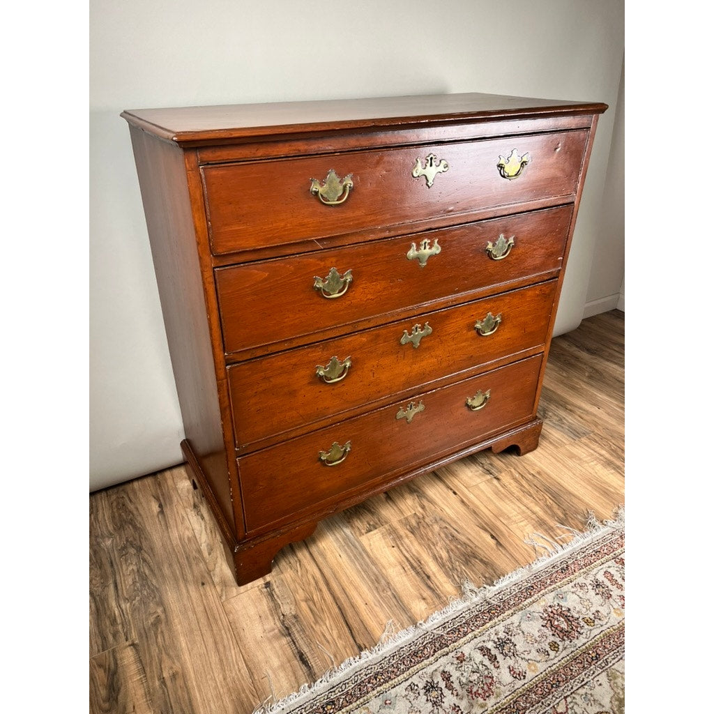 An Antique Chippendale Pine Graduated Four Drawer Chest, c. late 18th century (attr. Northampton MA maker), stands on a wood floor by a patterned rug against a light-colored wall.