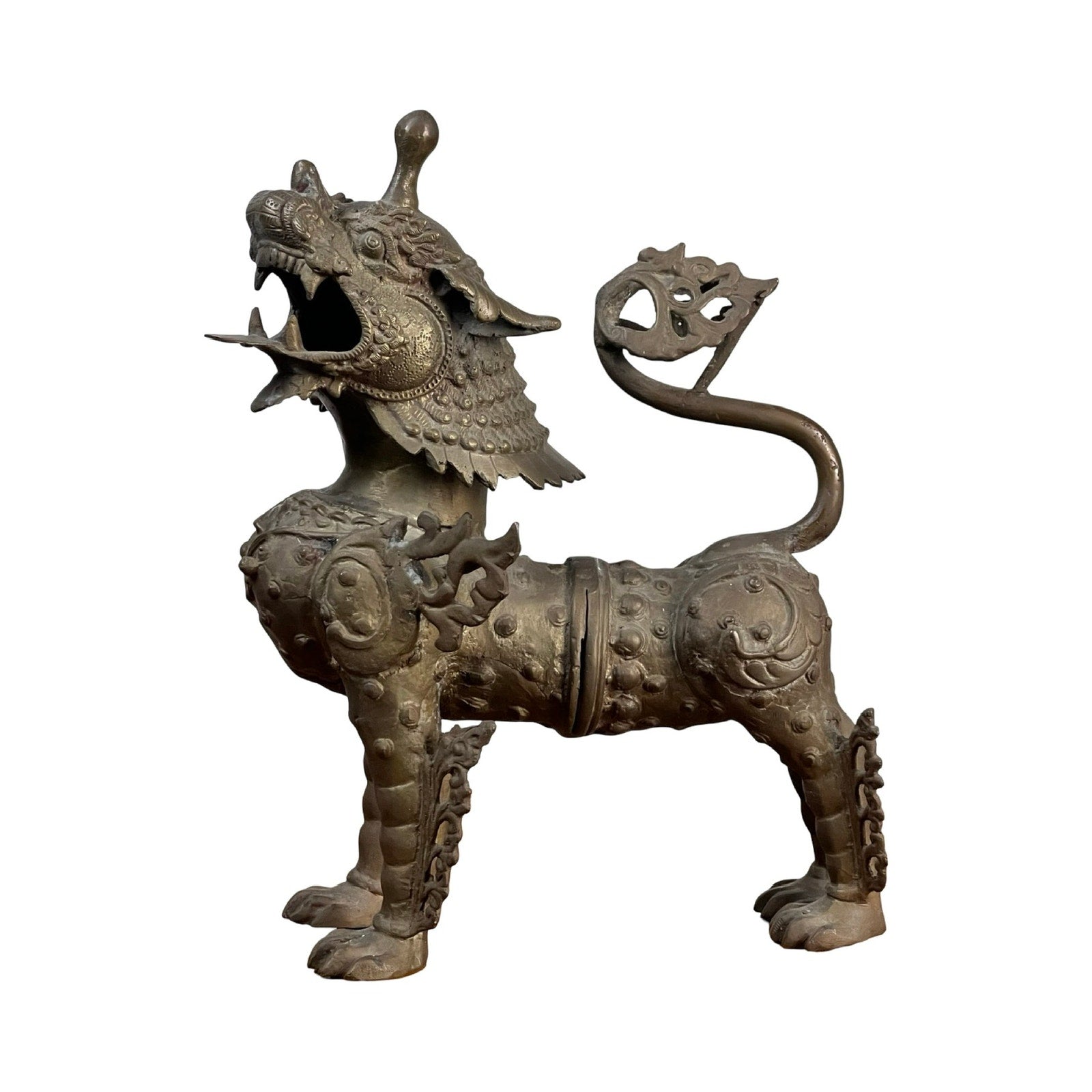A Vintage 17” Cast Brass Pixiu Tibetan Lion c. 1960 with ornate details, scales, a curled tail, and four legs stands out as a striking decor piece against a white background. Brand: None/Unknown.