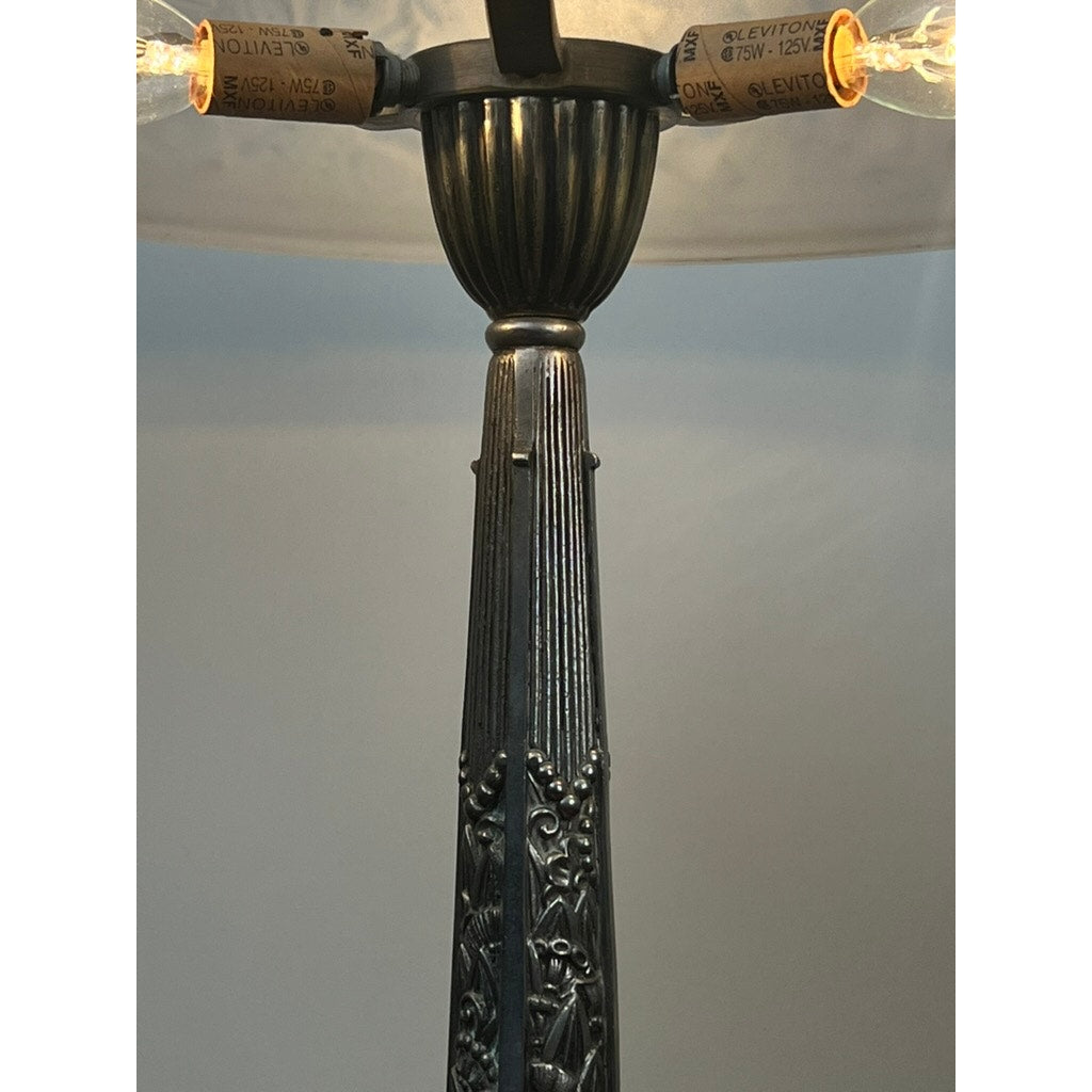 A close-up of a Vintage French Art Deco Frosted Glass Table Lamp by Muller Frères Lunéville c. 1920 with two exposed bulbs, wattage labels, floral engravings, and a ribbed design inspired by classic early 20th-century decor.