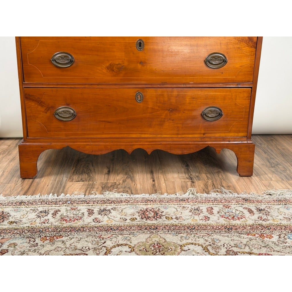 Pennsylvania Federal Cherry Four-Drawer Chest with Satinwood String Inlay, featuring two drawers, oval metal pulls, keyhole escutcheons, and a scalloped base.