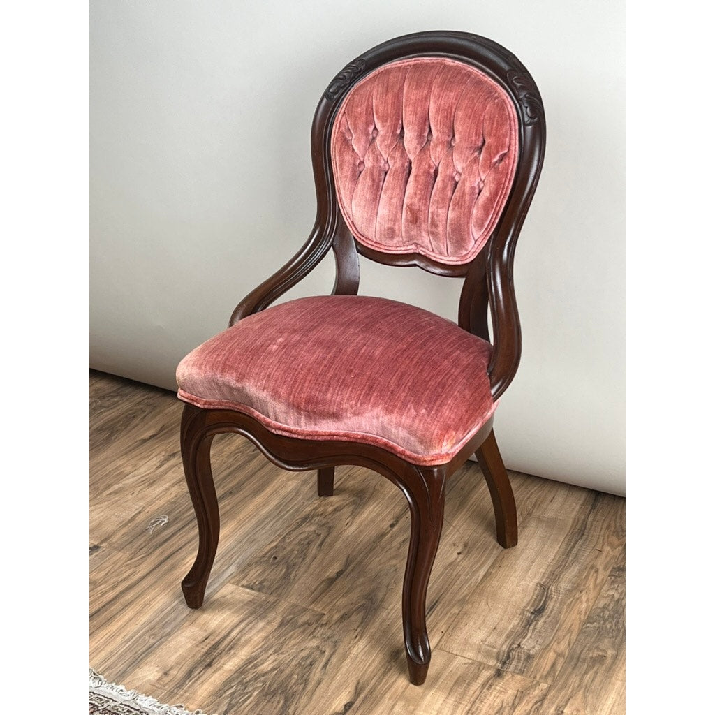 The Antique Victorian Walnut Tufted Balloon Back Side Chair c. Late 19th Century features a dark carved walnut frame, pink tufted velvet backrest and seat, and sits on a wooden floor against a light background. Brand: None/Unknown.