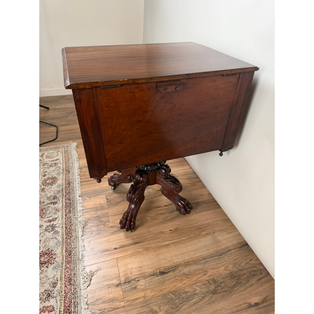 American Classical Figured Mahogany Work Table, circa 1830–1845 possibly New York or Philadelphia, featuring an antique rectangular top and a pedestal base with carved claw feet.