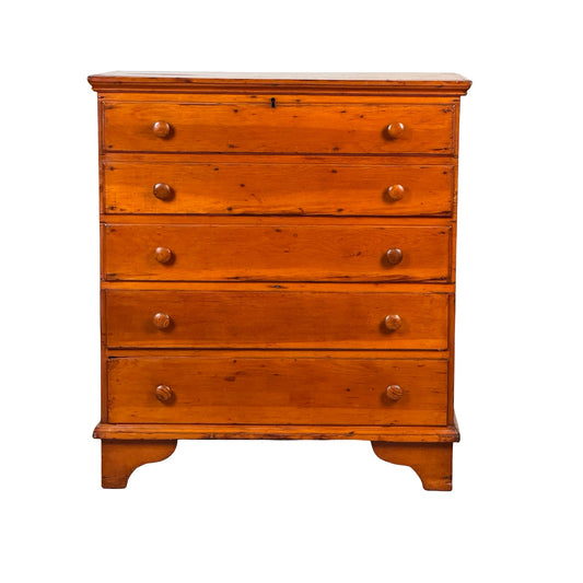A late 18th century New England pine two-drawer blanket chest, dating from circa 1780–1810, crafted in warm-toned wood and resting on short legs against a white backdrop, evokes the timeless charm of early American country furniture.
